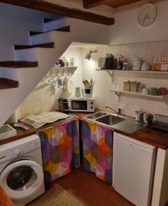 eine Küche mit einer Spüle und einer Waschmaschine in der Unterkunft Il Piccolo Borgo in Montalto di Castro