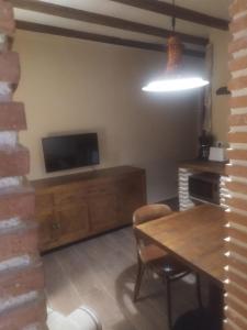 ein Wohnzimmer mit einem Holztisch und einem TV in der Unterkunft Alojamientos molino de revolcadores in Cañada de la Cruz