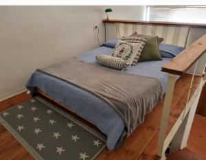 Bett mit blauer Bettdecke und Kissen darauf in der Unterkunft Il Piccolo Borgo in Montalto di Castro