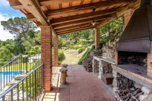 un patio al aire libre con chimenea de ladrillo y parrilla en Casa Rural Can Mananna Lloguer íntegre, en Sant Feliu de Buixalleu