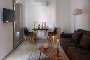 a living room with a couch and a table with chairs at MESSARIA APARTMENt in Mesaria