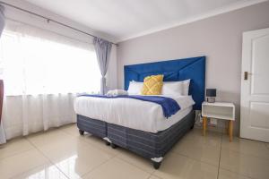 1 dormitorio con 1 cama grande y cabecero azul en Safi Luxury Apartment 7, en East London