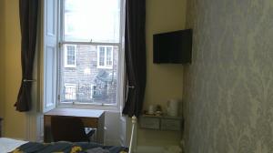 sypialnia z oknem, stołem i biurkiem w obiekcie IVY- Braveheart Guest House w Edynburgu