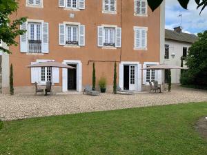 a large building with chairs and umbrellas in front of it at STUDIO EN VILLE ET CAMPAGNE in Louhans