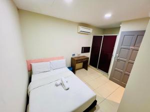 a room with a bed and a desk and a door at Swing & Pillows -MyHome Hotel Wangsa Maju in Kuala Lumpur