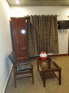 ein Wohnzimmer mit einem Stuhl und einem Couchtisch in der Unterkunft Rehan Hotel in Quetta