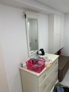 a bathroom with pink baskets on a dresser with a mirror at Pension Ella in Kaltensondheim +5 photos