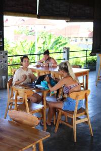a group of people sitting at a table in a restaurant at Sepeda Hostel in Canggu