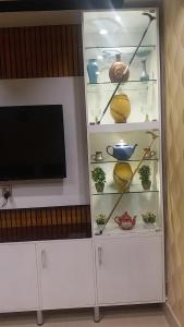 d'une armoire blanche avec une télévision et quelques casseroles et poêles. dans l'établissement Rehan Hotel, à Quetta