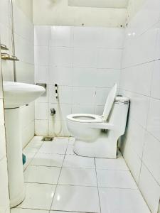 uma casa de banho branca com um WC e um lavatório em InTown Guesthouse em Islamabad