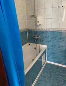 ein Badezimmer mit einer Badewanne mit blauen und weißen Fliesen in der Unterkunft Hotel Zoloti Vorota in Lalovo