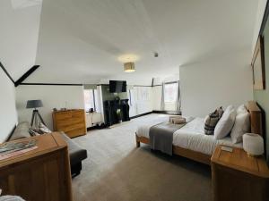 a large bedroom with a bed and a couch at The Fishmongers Tavern in Sheringham