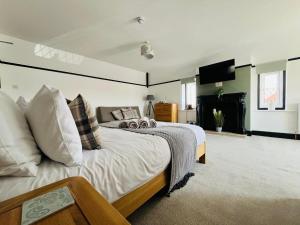 a bedroom with a large bed and a television at The Fishmongers Tavern in Sheringham