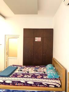 1 dormitorio con 1 cama y armario de madera en Nhà Nghỉ Minh Thảo, en Chơn Thành