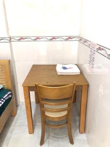 einen Holztisch und einen Stuhl in einem Zimmer in der Unterkunft Nhà Nghỉ Minh Thảo in Chơn Thành