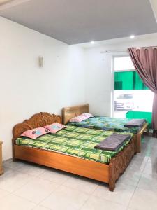two twin beds in a room with at Nhà Nghỉ Minh Thảo in Chơn Thành