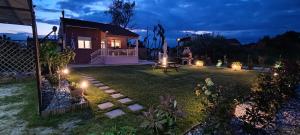 a person sitting in a yard at night with lights at Villa Kalliope in Keramoti
