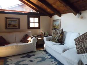 a living room with two white couches and a table at Baita del Plan in Pragelato