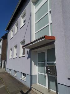Un edificio blanco con una puerta al costado. en TBM-Haus, en Homburg