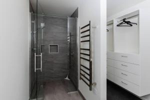 a bathroom with a shower with a glass door at The Buller Retreat in New Plymouth +25 photos