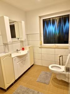 Un baño con inodoro y una ventana con luces azules. en TBM-Haus, en Homburg