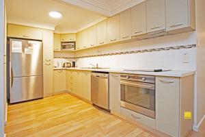 a kitchen with stainless steel appliances and wooden floors at Lesueur Days in Jurien Bay