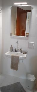 een badkamer met een wastafel, een toilet en een spiegel bij Vicky's Guesthouse in Kavos