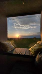 a bedroom window with a bed and a sunset at Posed Kubík in Žďár nad Sázavou