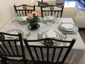 a table with plates and glasses and a vase with flowers at Luxury spa living in Jávea