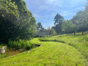 a path through a field with grass and trees at Le Clos Ste Thérèse by Idylliq 