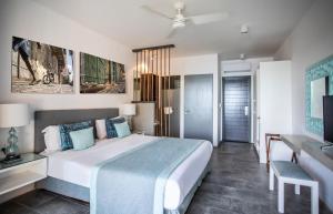 a hotel room with a large bed and a tv at La Mariposa Mauritius in Rivière Noire