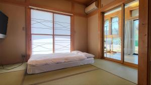 a bed in a room with a large window at プール バーベキュー場付き 貸し切り別荘 in Sano +26 photos