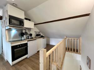 a kitchen with white cabinets and a microwave at Le Chalet - Home Homy in Montluçon