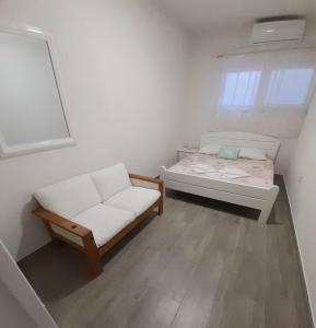 um pequeno quarto com uma cama e um sofá em Pension Alba em Podstrana