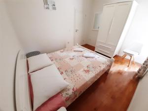 - une petite chambre avec un lit et une couverture rose dans l'établissement Pension Alba, à Podstrana