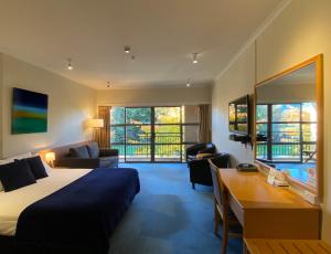 1 dormitorio con 1 cama y escritorio en una habitación en Saxton Lodge Motel en Nelson