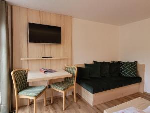 a living room with a couch and a table at Gasthaus Pension Donishäusle in Titisee-Neustadt