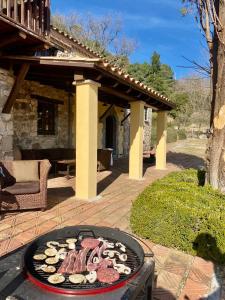 a grill with meat and mushrooms on a patio at Casa Rural Can Mananna Lloguer íntegre in Sant Feliu de Buixalleu +13 photos