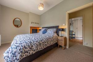 ein Schlafzimmer mit einem Bett mit einer blau-weißen Bettdecke in der Unterkunft Peony Cottage in Helhoughton