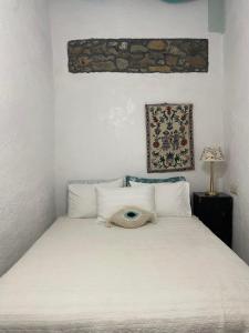 a bedroom with a white bed with a hat on it at Philoxenia traditional house in Pastida