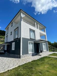 a large white house on top of a grass field at Villa Deluxe Panorama 61 in Trabzon