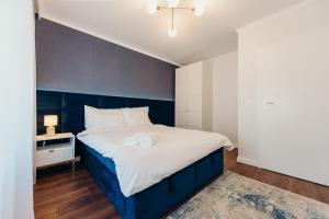 a bedroom with a large bed with a blue headboard at 3 Bedrooms Premium Bella Blue for 8 Guests with AC and Free out side Parking in Rzeszów