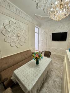 a living room with a couch and a table with flowers at Boulevard in Bukhara
