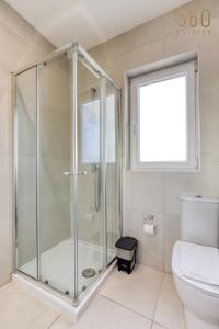 a bathroom with a shower and a toilet at Lovely designer 3BR Apt with Private Terrace with BBQ by 360 Estates in Tal-Pietà +44 photos