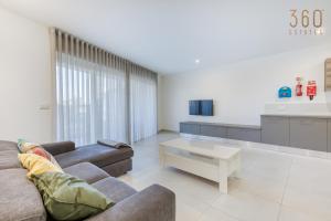 a living room with a couch and a coffee table at Lovely designer 3BR Apt with Private Terrace with BBQ by 360 Estates in Tal-Pietà