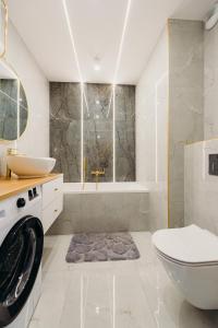 a bathroom with a toilet and a tub and a sink at 3 Bedrooms Premium Bella Blue for 8 Guests with AC and Free out side Parking in Rzeszów +35 photos