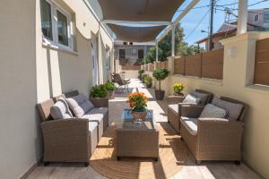 a patio with wicker chairs and a table on a balcony at Olivia’s House in Kavos