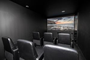 a cinema room with chairs and a large screen at Ereza Villas Alicia in Caleta De Fuste