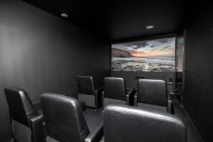 a cinema room with chairs and a large screen at Ereza Villas Alicia in Caleta De Fuste +15 photos