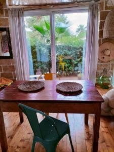 una mesa de madera con dos platos delante de una ventana en Cottage nel verde, en Nardò